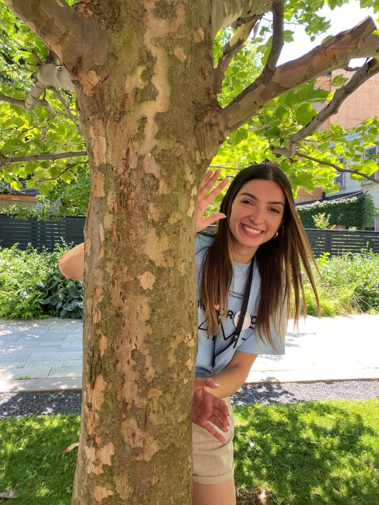 Julia waves from behind a tree